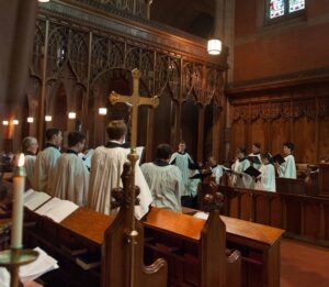 Members of the Christ Church Choir face the Choirmaster and sing in church.