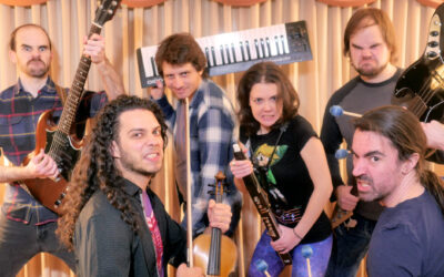 The band DiscoCactus stands in a fighting pose holding their instruments as pretend video game weapons