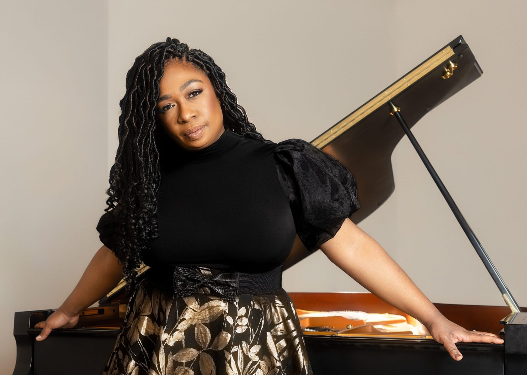 Michelle Cann stands in front of an open piano.